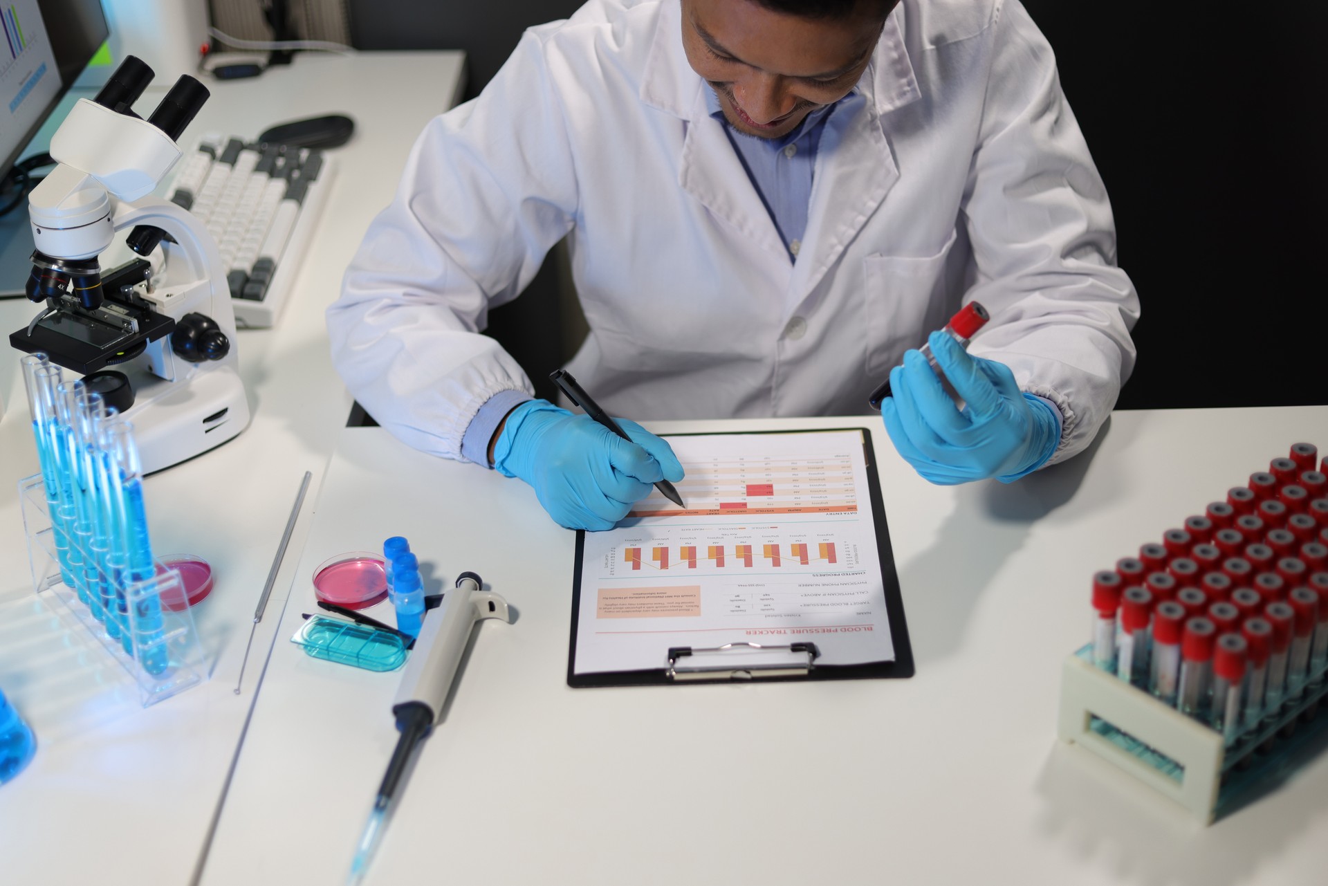 Scientists test the chemical reactions of the colored liquid solution and test biological fluids in test tubes.